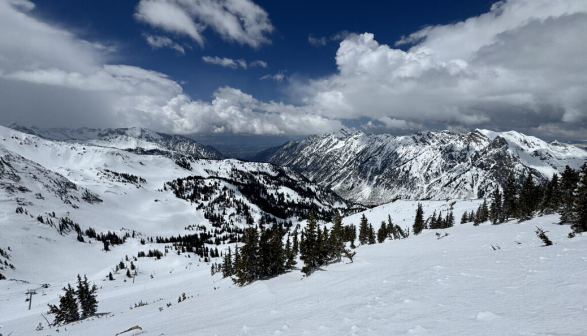 Snowy ski slopes with the Salt Lake Valley in the background, seen from the top of Snowbird